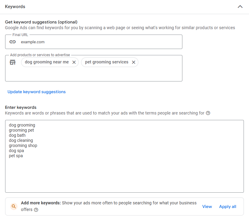 Google Ads keyword setup screen showing keyword suggestions and manual entry options. The 'Final URL' is set to 'example.com', and products or services to advertise are listed as 'dog grooming near me' and 'pet grooming services'. Under 'Enter keywords', several keywords are entered: 'dog grooming', 'grooming pet', 'dog bath', 'dog cleaning', 'grooming shop', 'dog spa', and 'pet spa'. A prompt at the bottom suggests adding more keywords to show ads more often, with options to 'View' or 'Apply all' suggested keywords.