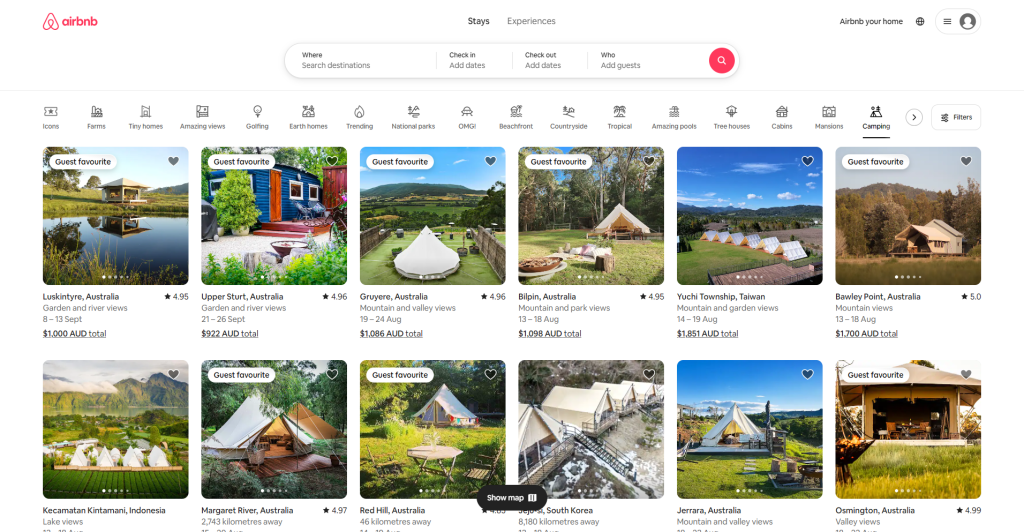 A screenshot of Airbnb's website showcasing a selection of unique accommodation listings. The layout is clean and visually appealing, with a white background that highlights the colorful images of properties. Each listing features a high-quality photo, the location, guest ratings, and pricing information. The top navigation bar includes Airbnb's logo in red, along with options for filtering stays and experiences. The use of white space and a minimalist design ensures that the focus remains on the property images and key details, making it easy for users to browse and compare options. The website effectively uses color and layout to create a user-friendly and visually engaging experience.